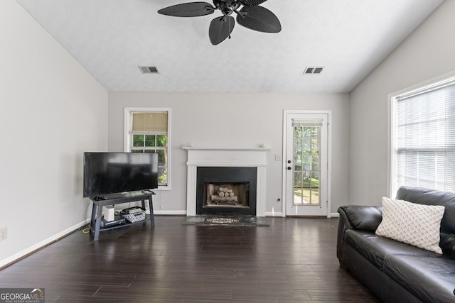 living area featuring a fireplace, a healthy amount of sunlight, a ceiling fan, and visible vents