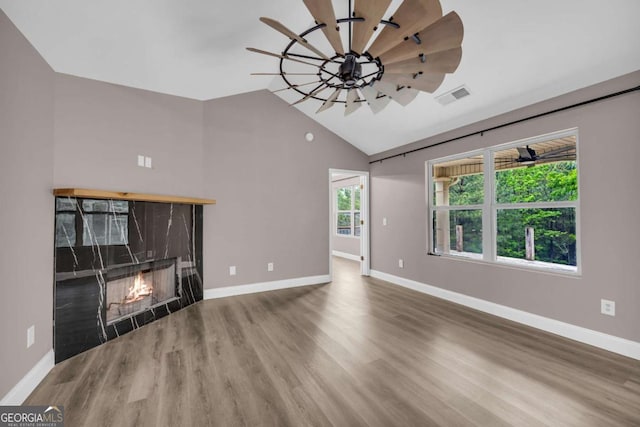 220 Makers Way, Dawsonville, GA 30534 - unfurnished living room featuring lofted ceiling, a high end fireplace, wood finished floors, visible vents, and baseboards