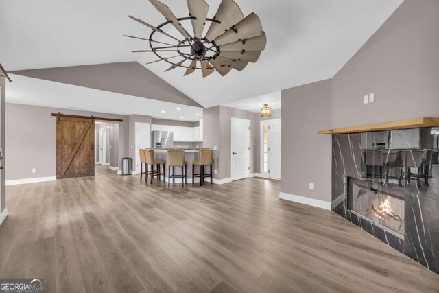 220 Makers Way, Dawsonville, GA 30534 - living room with baseboards, a fireplace, a barn door, and high vaulted ceiling