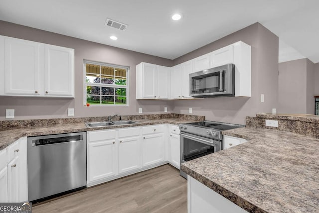 220 Makers Way, Dawsonville, GA 30534 - kitchen featuring visible vents, a sink, white cabinetry, light wood-style floors, and appliances with stainless steel finishes