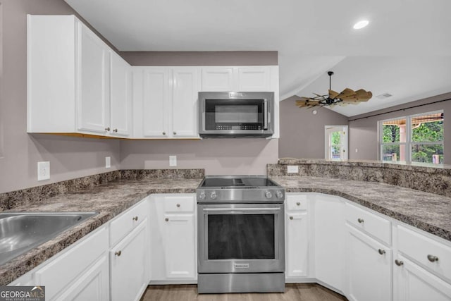 220 Makers Way, Dawsonville, GA 30534 - kitchen featuring white cabinets, appliances with stainless steel finishes, and vaulted ceiling
