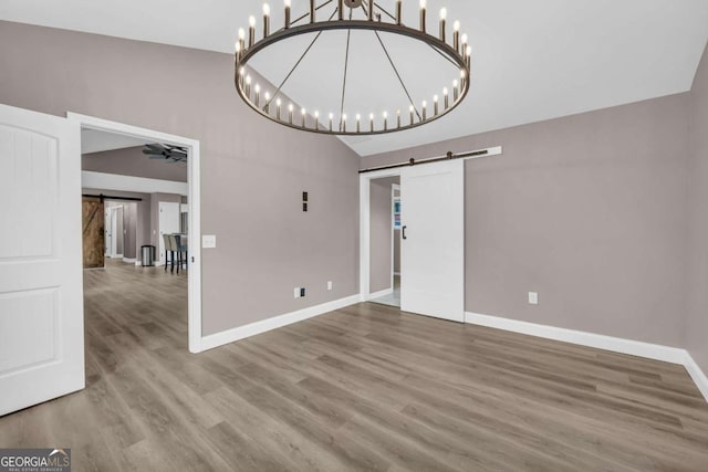 220 Makers Way, Dawsonville, GA 30534 - unfurnished dining area with wood finished floors, a chandelier, a barn door, and baseboards