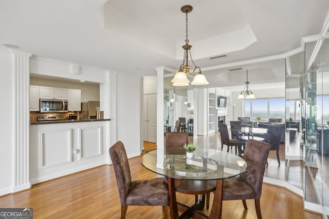 3475 Oak Valley Rd NE Unit 2060, Atlanta, GA 30326 - dining area with a fireplace, a raised ceiling, visible vents, and light wood-style floors