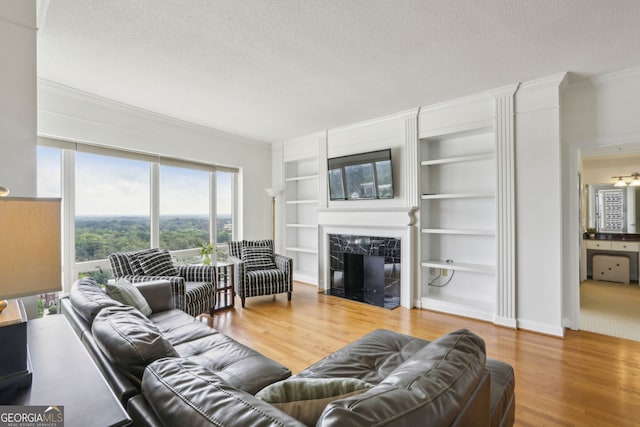 3475 Oak Valley Rd NE Unit 2060, Atlanta, GA 30326 - living room featuring built in features, crown molding, a textured ceiling, and wood finished floors