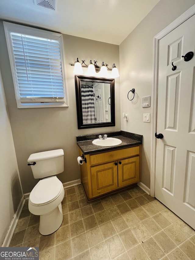 bathroom with vanity, toilet, and baseboards