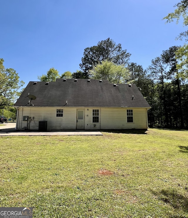 back of property with a lawn, a patio, and central AC