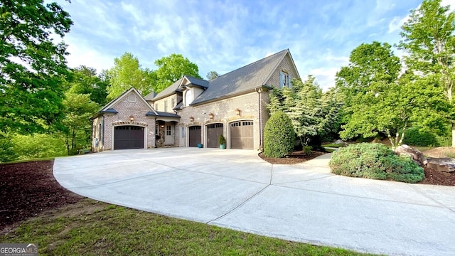 view of side of home featuring a garage, brick siding, and driveway