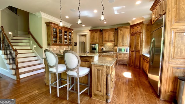 1345 Cashiers Way, Roswell, GA 30075 - kitchen featuring built in appliances, brown cabinets, ornamental molding, dark wood-style flooring, and a kitchen breakfast bar