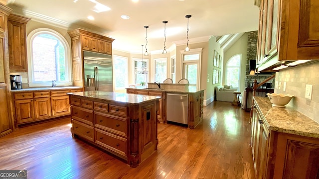 1345 Cashiers Way, Roswell, GA 30075 - kitchen featuring appliances with stainless steel finishes, a center island, brown cabinets, ornamental molding, and dark wood-style flooring