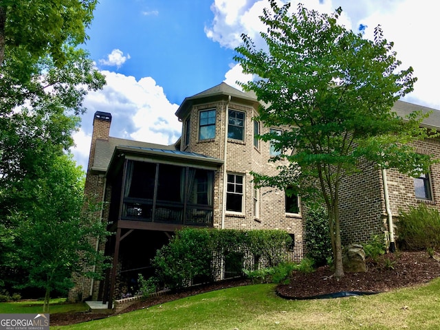 1345 Cashiers Way, Roswell, GA 30075 - back of property with a sunroom, brick siding, a chimney, and a yard