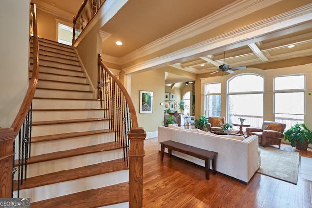 living area with crown molding, stairs, ceiling fan, and wood finished floors