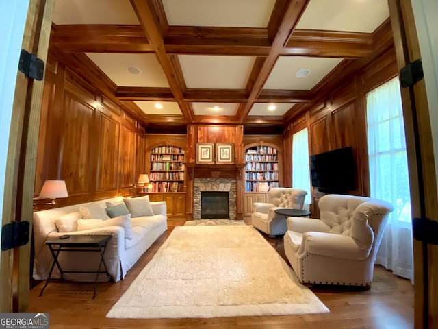 living room featuring wood walls, beam ceiling, a fireplace, wood finished floors, and coffered ceiling