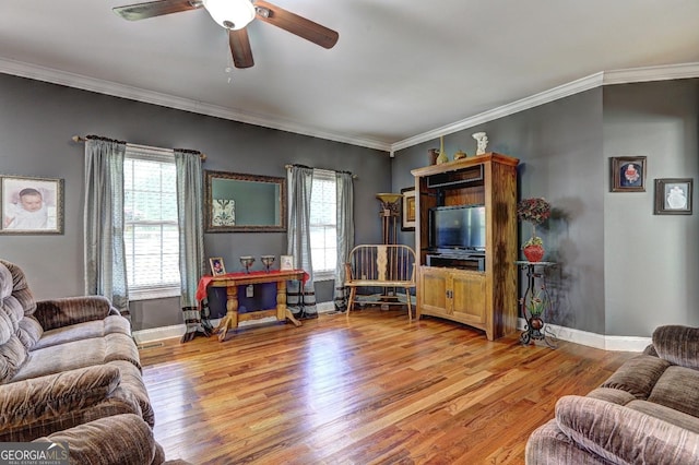 living room with a wealth of natural light, ornamental molding, ceiling fan, and light wood-style floors
