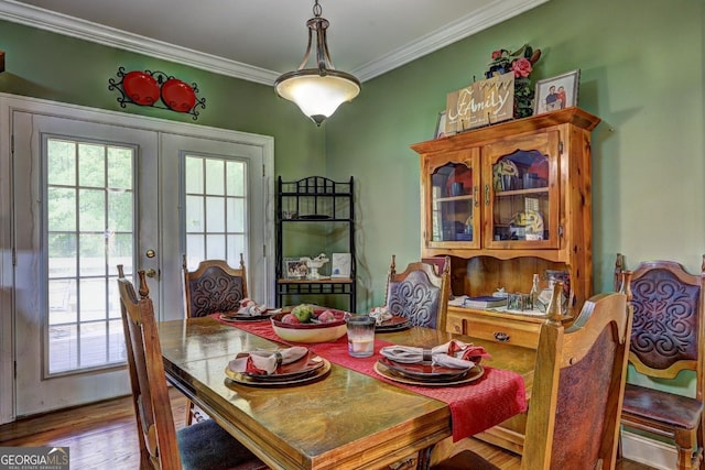 dining area with crown molding, french doors, and wood finished floors