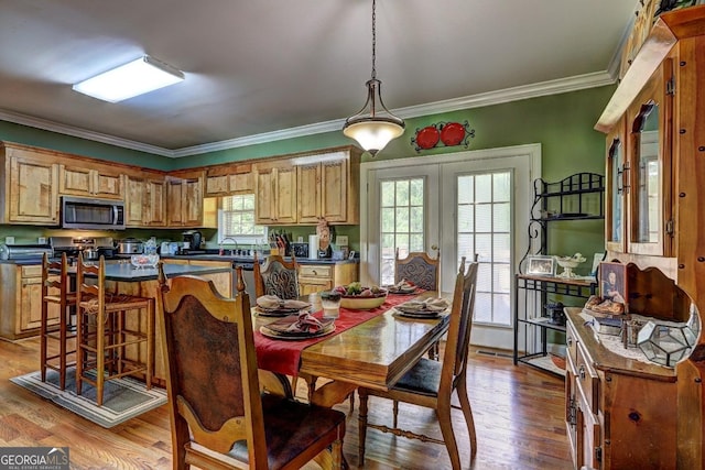 dining room with ornamental molding, french doors, and wood finished floors