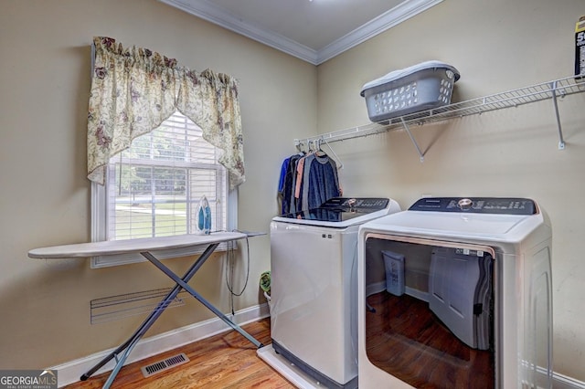 laundry area with independent washer and dryer, ornamental molding, visible vents, wood finished floors, and laundry area