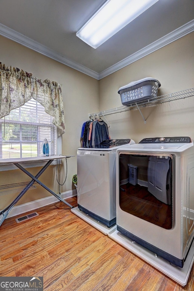 washroom featuring visible vents, separate washer and dryer, crown molding, and wood finished floors