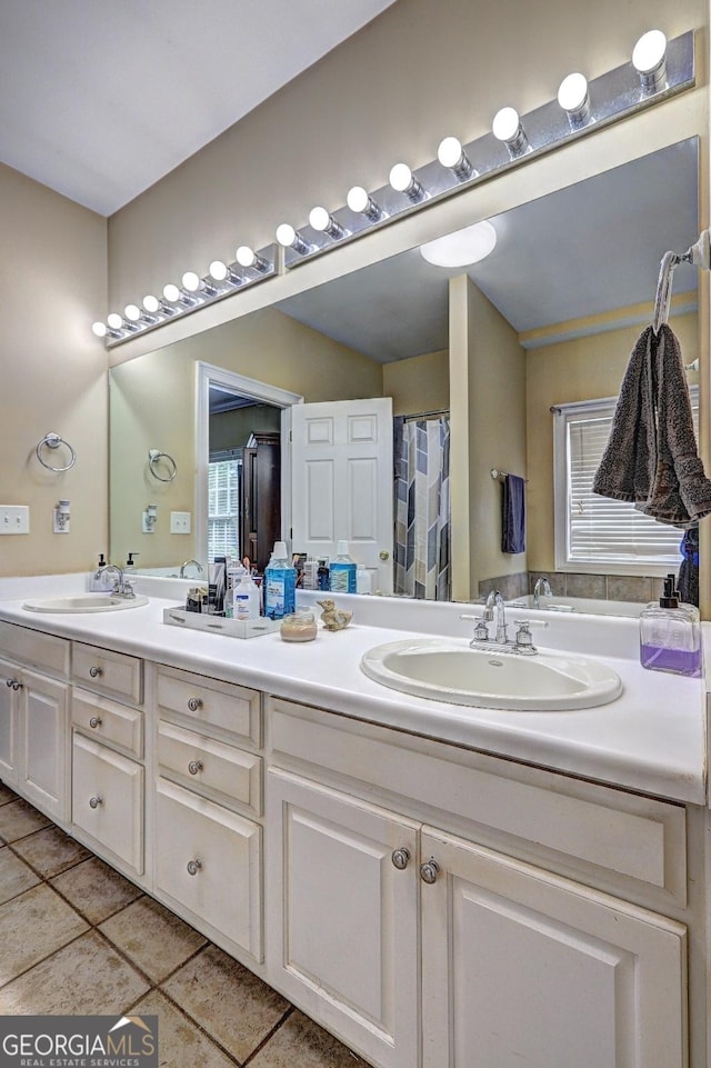 bathroom with a sink, double vanity, and tile patterned floors
