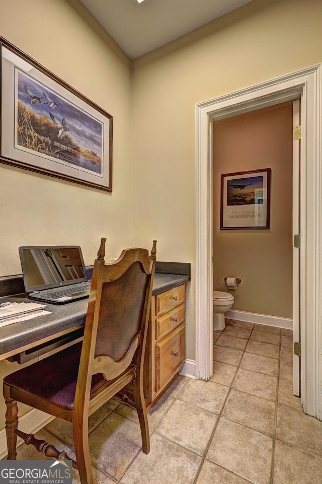 home office with light tile patterned floors and baseboards