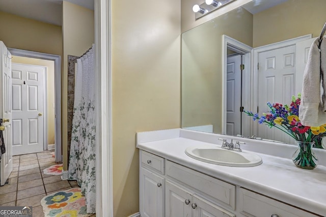 bathroom with baseboards, tile patterned flooring, and vanity