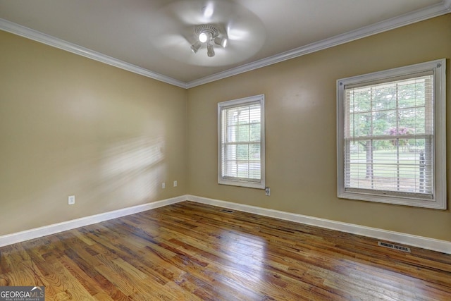 unfurnished room with wood finished floors, visible vents, baseboards, ceiling fan, and ornamental molding