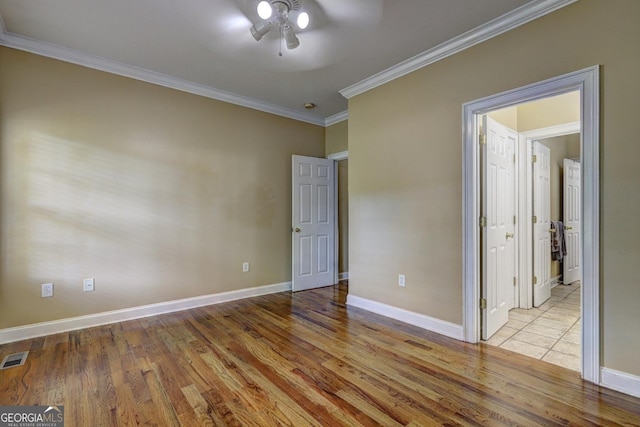 unfurnished bedroom with crown molding, wood finished floors, and baseboards