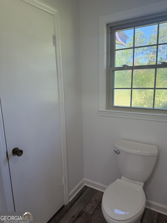bathroom featuring a wealth of natural light, baseboards, toilet, and wood finished floors