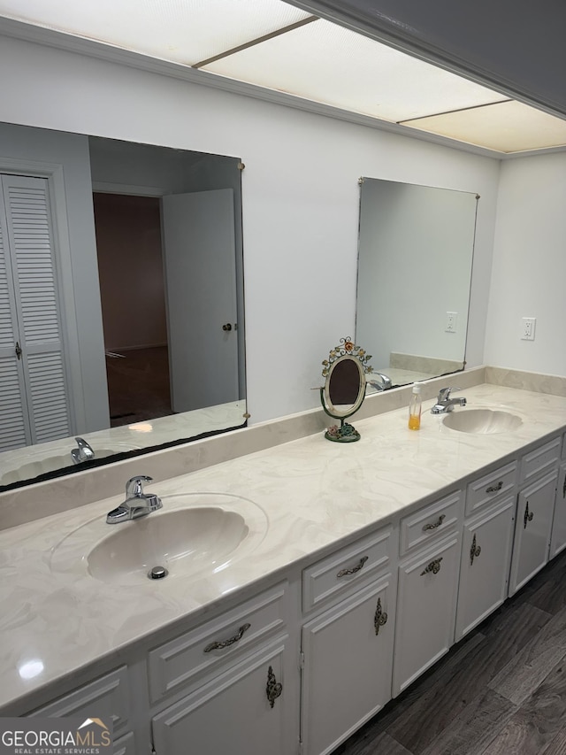 full bath featuring double vanity, a closet, wood finished floors, and a sink