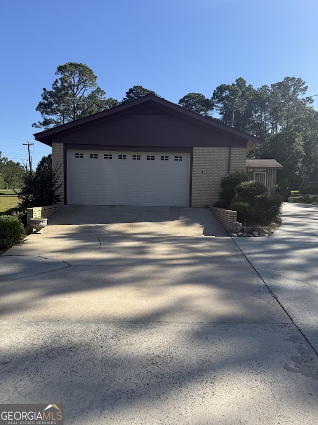 view of front of property with concrete driveway, a garage, and brick siding