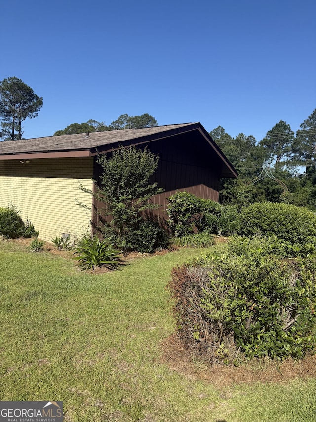 view of side of home with a yard and brick siding