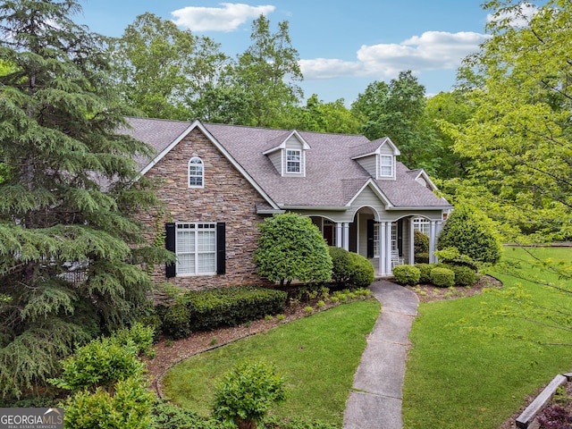 6125 Fouts Mill Rd, Douglasville, GA 30135 - new england style home featuring a shingled roof, a front lawn, and stone siding