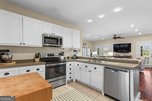 1261 Otter Slide Loop NE, Townsend, GA 31331 - kitchen featuring stainless steel appliances, a peninsula, open floor plan, a sink, and ceiling fan