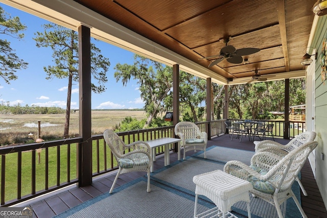 1261 Otter Slide Loop NE, Townsend, GA 31331 - wooden terrace featuring a ceiling fan, outdoor dining area, a yard, and a view of countryside