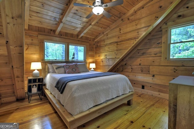 bedroom featuring wooden ceiling, light wood-style flooring, lofted ceiling with beams, and multiple windows
