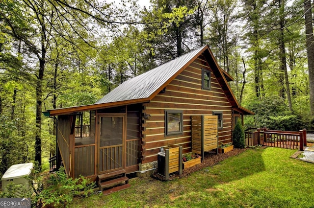 view of outdoor structure featuring a wooded view and fence