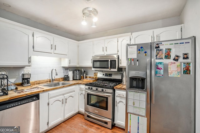 2716 Suwanee Way SE, Marietta, GA 30067 - kitchen with wooden counters, light wood-style flooring, a sink, stainless steel appliances, and white cabinetry