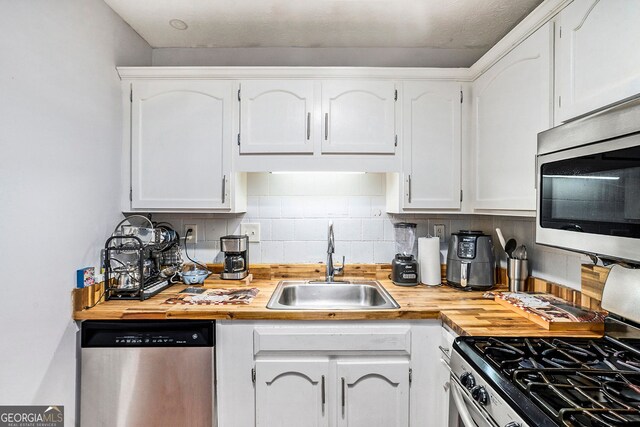 2716 Suwanee Way SE, Marietta, GA 30067 - kitchen with a sink, white cabinetry, decorative backsplash, and appliances with stainless steel finishes