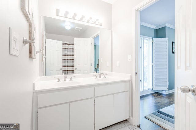 full bathroom with baseboards, double vanity, and a sink