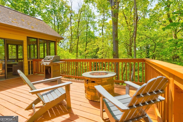 wooden terrace featuring a fire pit and grilling area
