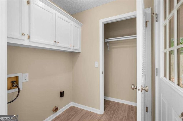 196 Highland Dr, Calhoun, GA 30701 - clothes washing area with baseboards, hookup for a washing machine, wood finished floors, cabinet space, and electric dryer hookup