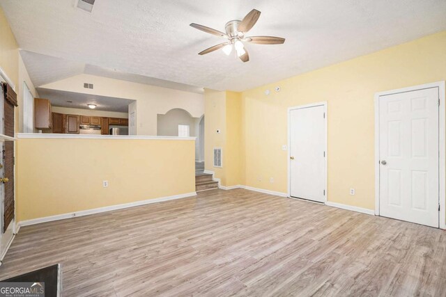 2722 S Hills, Riverdale, GA 30296 - unfurnished living room featuring light wood-style flooring, a ceiling fan, visible vents, baseboards, and arched walkways