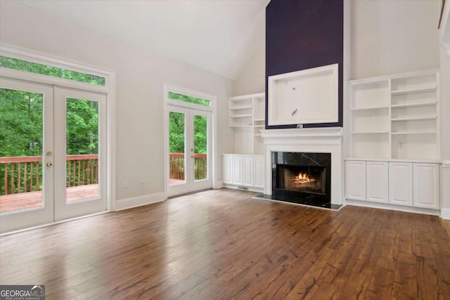 unfurnished living room featuring a premium fireplace, dark wood-style flooring, and french doors