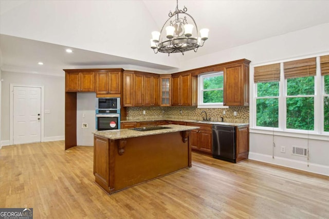 kitchen featuring tasteful backsplash, brown cabinets, dishwashing machine, visible vents, and black electric cooktop