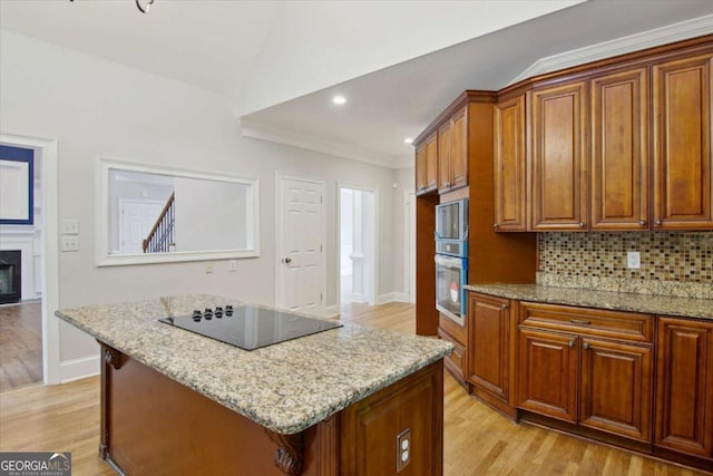 kitchen with black electric cooktop, baseboards, light wood-style flooring, and brown cabinets