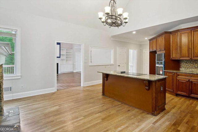 kitchen with baseboards, light wood finished floors, visible vents, a chandelier, and black electric cooktop