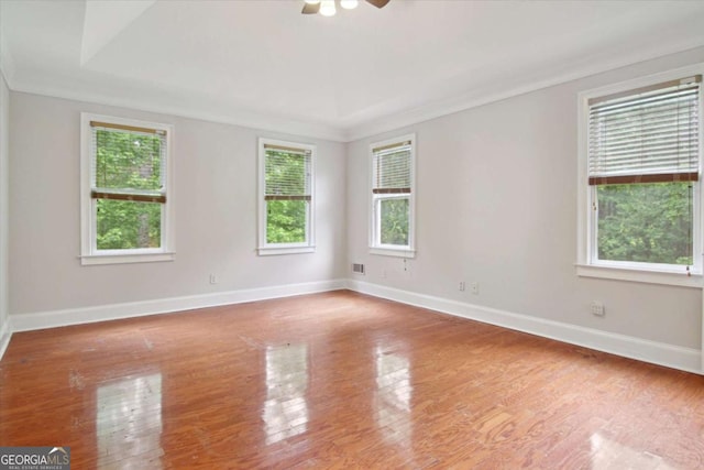 empty room with wood finished floors, visible vents, baseboards, and a ceiling fan
