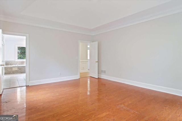 empty room featuring baseboards, visible vents, and wood finished floors