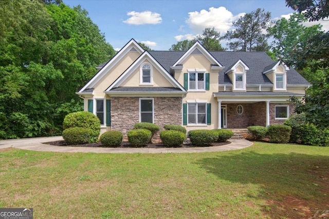 craftsman-style home featuring stone siding, stucco siding, and a front lawn