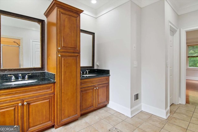 bathroom with double vanity, visible vents, baseboards, and a sink