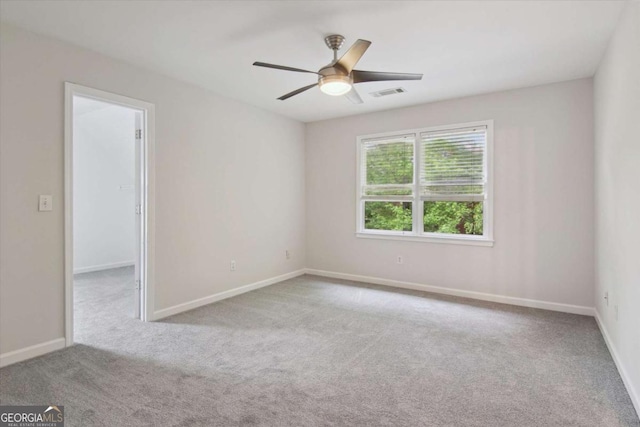 unfurnished room with visible vents, baseboards, a ceiling fan, and carpet floors